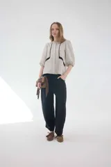 Pantalón negro de lino de tiro medio, con calce holgado, piernas amplias y bolsillos delanteros y traseros.