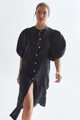 Vestido midi negro confeccionado en lino, con cuello mao, mangas abullonadas hasta el codo y cierre frontal con botones de nácar.