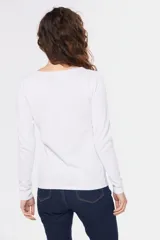 Buzo de tejido de punto con diseño bicolor, combinando blanco en la parte superior y mangas con un tono celeste grisáceo en el cuerpo, presentando un patrón geométrico en la unión de los colores. Posee cuello redondo y mangas largas.