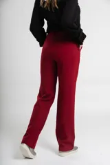 Pantalón de vestir azul marino, de corte recto, con bolsillos laterales y traseros. Se ajusta a la cintura con cinturón de cuero marrón.