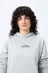 Canguro negro con capucha y bolsillo delantero. Presenta un bordado frontal y trasero con lettering “Mont Saint-Michel”.