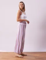 Pantalón wide leg de lino con cintura elastizada y estampado a rayas verticales en tonos lila, rosa, gris y blanco.