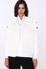 Chaleco negro de piel sintética con diseño de trenzas y cuello tipo camisa.