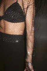 Top de red negro con strass, mangas largas y cuello redondo. Incluye corpiño negro con breteles finos.