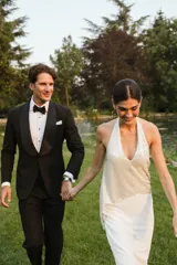 Vestido largo de novia color blanco, con cuerpo superior estilo halter de lentejuelas brillantes y falda larga fluida y ajustada.