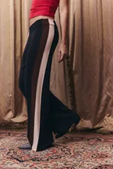 Pantalón tejido de corte recto y holgado, con cintura elástica. Presenta un diseño tricolor en los laterales con franjas verticales en negro, marrón y beige.
