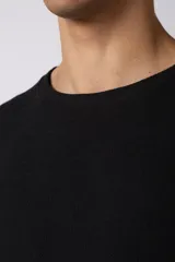 Remera de corte oversize confeccionada en tejido texturado tipo lino, de color beige, con cuello redondo amplio y mangas cortas de calce relajado.