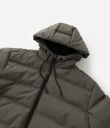 Campera puffer deportiva color verde militar, sin costuras, con capucha ajustable por cordón, bolsillos laterales con cierre y cierre frontal por cremallera.