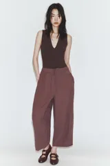 Pantalón de tiro medio con corte estilo balloon, cintura elástica ajustable con cordones, bolsillos laterales ocultos y bolsillos de plastrón en la parte trasera.