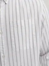 Camisa de manga larga Jack & Jones, confeccionada en tejido Oxford de algodón 100%. Diseño a rayas verticales en tonos beige y blanco, con cuello abotonado, bolsillo en el pecho y corte regular.