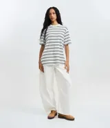 Remera oversized de algodón BCI, color blanco con rayas horizontales negras, cuello redondo y mangas cortas.