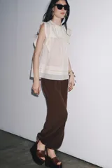 Blusa blanca sin mangas confeccionada en hilatura con viscosa y algodón. Tiene cuello redondo, detalle de bordados a contraste y cierre en espalda con abertura y botón.