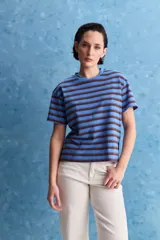 Remera de calce relajado con diseño a rayas horizontales blancas y verdes, hombros caídos y mangas amplias con vuelta. Presenta cuello redondo y ruedo trasero levemente más largo.