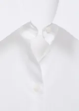 Camisa de corte recto confeccionada en una mezcla de algodón y lyocell. Presenta cuello camisero clásico, cierre frontal con botones y mangas largas con puños abotonados.