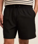 Bermuda masculina color beige, tipo boardshort, confeccionada en microfibra. Cuenta con cintura elástica, cordón ajustable y bolsillos.