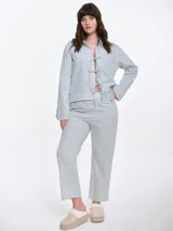 Pantalón de dormir de corte recto y calce relajado, confeccionado en popelina de algodón con estampado de rayas verticales y pequeños puntos bordados. Presenta cintura elastizada para mayor comodidad.