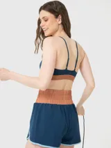 Top deportivo de sujeción media con diseño ajustado y detalle bicolor en la banda inferior. Confeccionado en tejido suave y elástico con tecnología Aloe Vera.