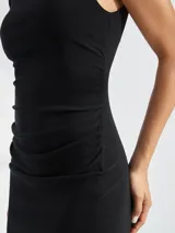 Vestido midi negro sin mangas, de corte ajustado con frunces laterales y abertura alta en la pierna.