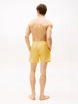 Short de baño amarillo con cintura elástica y cordón ajustable.