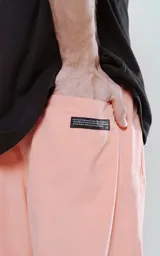 Pantalon de corte sastrero y estilo holgado, confeccionado en tela con textura suave tipo gamuza. Presenta cintura con cierre y botón frontal, ajuste elástico trasero con tanca y bolsillos laterales.