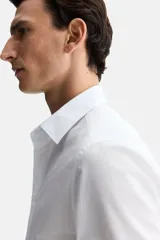 Camisa de corte entallado con cuello inglés, tapeta clásica y canesú en la espalda. Presenta mangas largas con puños ajustables mediante botones y bajo levemente redondeado. Confeccionada en tela con tratamiento de fácil planchado.