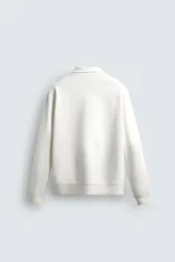 Sudadera polo azul marino de corte regular fit, confeccionada en tejido técnico interlock de algodón con elasticidad. Presenta cuello solapa, cierre frontal de cremallera y manga larga con acabados en rib.