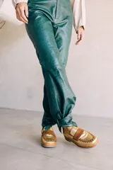 Mocasines de cuero con diseño bicolor en tonos dorado y marrón, silueta clásica, detalle artesanal trenzado en el frente y suela de base firme.