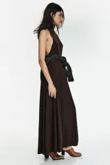 Vestido largo de corte evasé, con cuello subido y diseño sin mangas. Presenta cierre en la espalda con botones y una caída fluida.