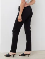 Pantalón de vestir negro de corte recto y entallado, con nervadura central vertical que estiliza la silueta. Presenta cintura ancha de soporte, panel de malla interna para control abdominal y bolsillos posteriores simulados.