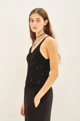 Musculosa de tejido rib al cuerpo con escote en V y detalle de lentejuelas bordadas a tono.