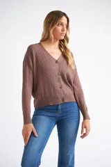 Cárdigan de tejido liviano con textura acanalada, cuello en V y cierre frontal con botones. Presenta mangas largas y un diseño clásico con detalle de grifa en cuero.