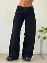 Pantalón de jean negro de tiro bajo con corte wide leg y diseño de cinco bolsillos. Confeccionado en denim rígido.