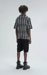 Camisa de manga corta, tejida de punto abierto (símil crochet), con estampado paisley en blanco y negro, y calce oversize.