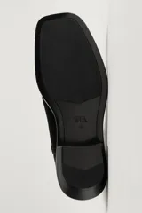 Bota estilo cowboy fabricada en piel con acabado serraje y parte superior lisa. Cuenta con horma cuadrada, cierre mediante cremallera lateral y suela con ligero tacón.