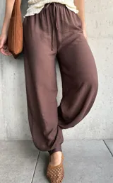 Pantalón de corte babucha color chocolate, de diseño holgado con cintura elástica fruncida y cordón ajustable.
