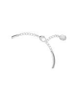 Brazalete rígido plateado con forma de lazo adornado con cristales transparentes.