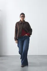 Tapado corto de paño con textura, color marrón, de corte recto y silueta estructurada. Presenta cuello camisero, cierre frontal con botones grandes y mangas largas con detalle de trabas en los puños.
