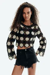 Short de denim negro de tiro superalto y corte clásico de cinco bolsillos, con detalles desgastados y bajos deshilachados.