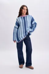 Sweater de punto con diseño de rayas verticales en tonos de azul y celeste, con cuello redondo en color rosado.