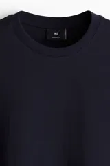 Remera de manga larga color azul marino oscuro, confeccionada en punto de algodón liviano, con cuello redondo ribeteado y bajo recto.