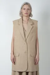 Chaleco largo color beige de lino y viscosa, con solapas y cierre con dos botones.