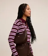 Cartera baguette pequeña de material sintético color marrón, sin estampa, con correa de mano y cierre de cremallera. No incluye pañuelo.