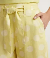Short recto amarillo con estampado de lunares blancos, cintura alta con cinturón para atar y bolsillos laterales.