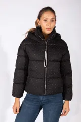 Campera puffer negra con capucha, diseño acolchado y estampado de pequeños puntos brillantes. Cuenta con cierre frontal y tirador decorativo con strass.