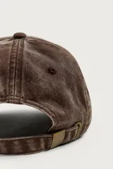 Gorra de seis paneles marrón con efecto lavado, visera curva y texto bordado en relieve en la parte frontal en tonos rojo y amarillo.