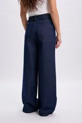 Pantalon de jean ancho azul oscuro con alforzas frontales y diseño de tiro alto.