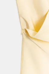 Top de tejido satinado con cuello halter y escote en pico cruzado. Presenta un diseño de espalda descubierta y bajo asimétrico con cierre lateral.