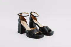 Sandalias de cuero negro con plataforma y tacón cuadrado. Tienen pulsera con hebilla al tobillo.