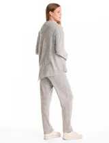 Buzo de calce suelto confeccionado en tejido suave melange color gris. Presenta cuello volcado con botones decorativos en el hombro izquierdo, mangas largas con hombros caídos y ruedo asimétrico con terminación en punta.