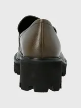Mocasín de cuero color verde oliva con textura granulada, diseño clásico con antifaz y suela track de plataforma alta en color negro.